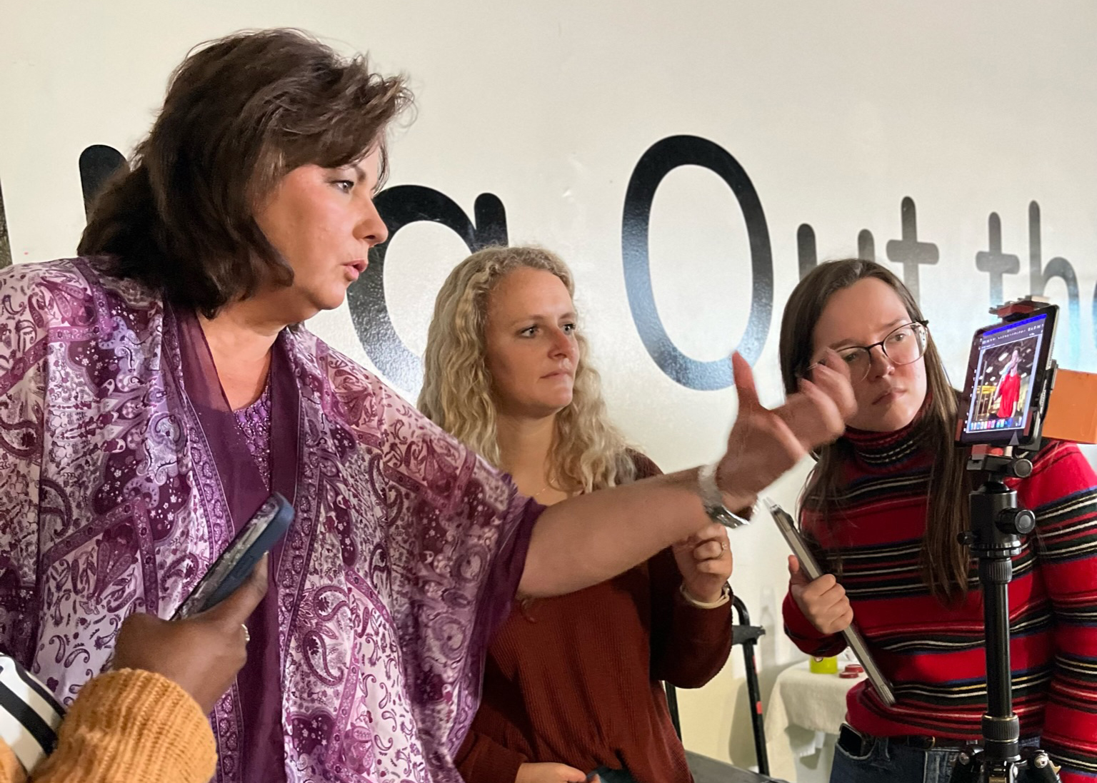a group of women standing in a room looking at a video monitor