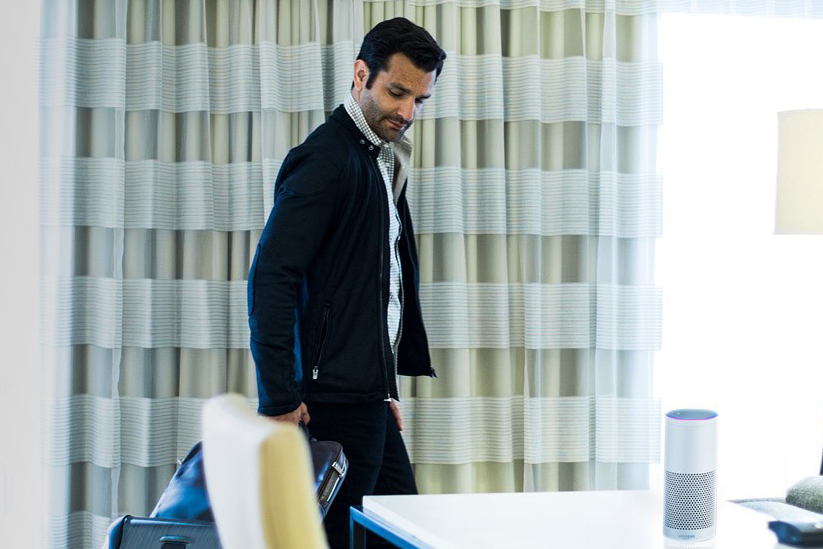Crowne Plaza man in a black jacket with suitcase entering a hotel room