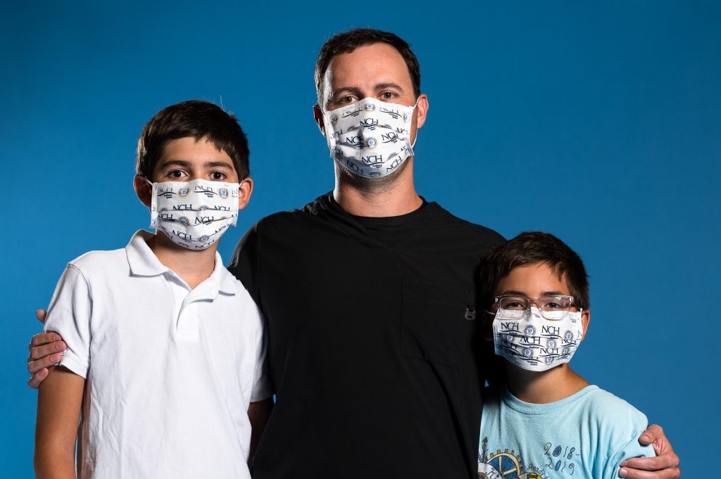 NCH All Heroes Wear Masks image of a father with two sons all wearing masks