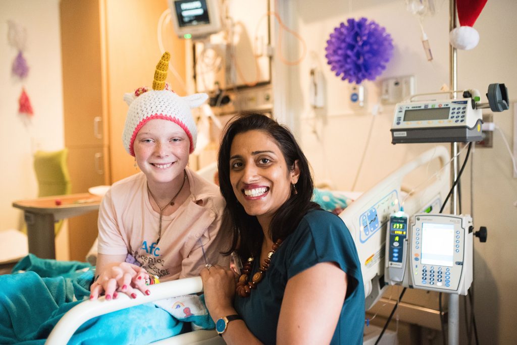 CHOA heart swap young girl patient with a nurse kneeling at hospital bed