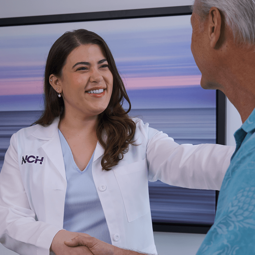 Smiling female doctor consulting with patient at Naples Comprehensive Health representing compassionate healthcare in Southwest Florida